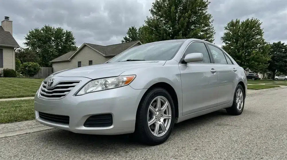 Kenda Tires Review: Are Kenda Tires good? 4 Kenda Kenetica Touring A/S mounted on a silver sedan in a suburban