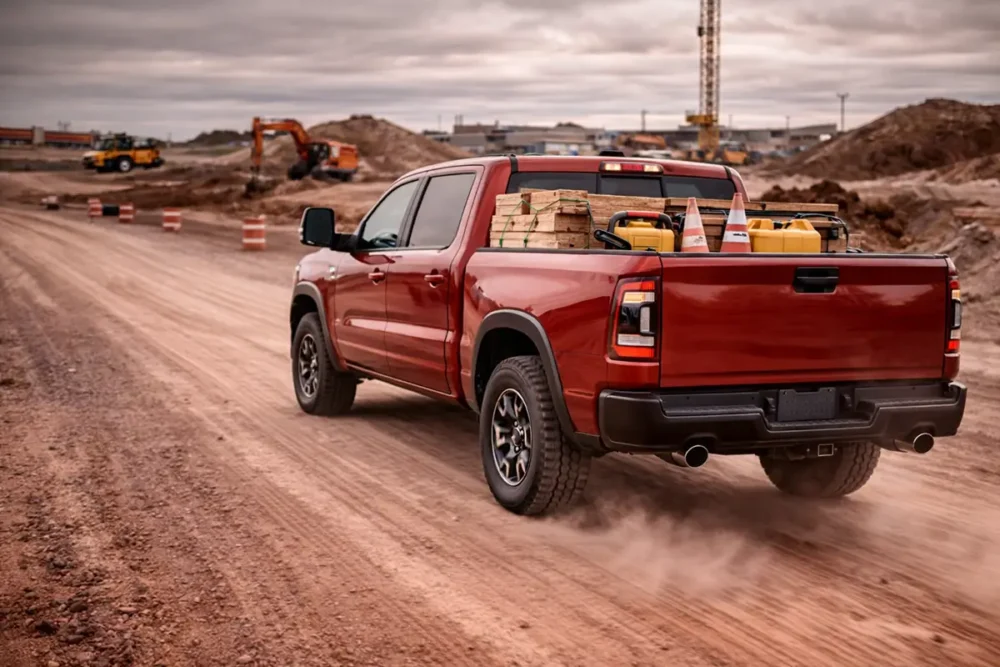 Heavy duty work truck fully loaded with cargo in bed driving on a construction site road, 10 ply tires