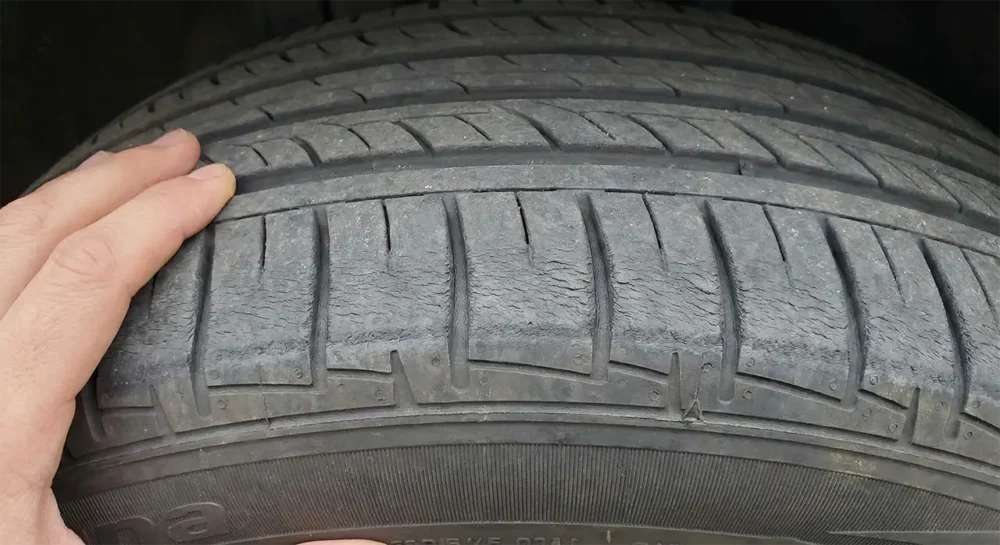 How to Maintain Your Wheels: A Real-World Testing Guide 9 Pointing out uneven "feathered" wear on the edge of the tire tread, a sign of poor alignment.