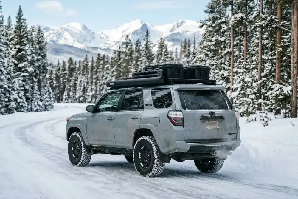 HT vs. AT vs. MT Tires: Which Is Right for You? 10 Toyota 4Runner with AT tires driving on snow-covered mountain road
